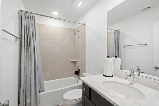 a bathroom with a granite countertop sink toilet and shower