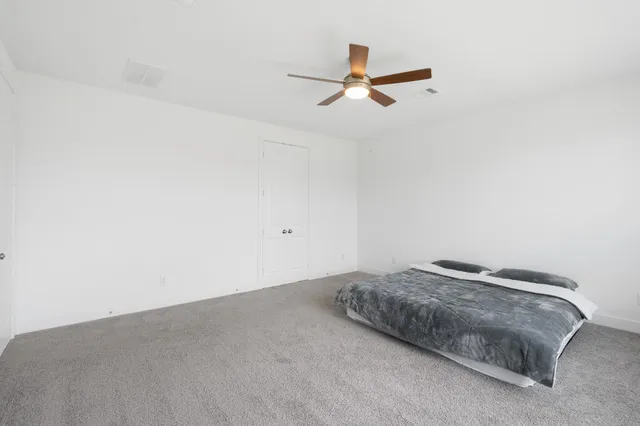 a bedroom with a bed and ceiling fan