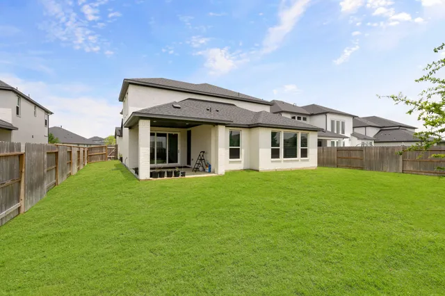 a view of a house with backyard and porch