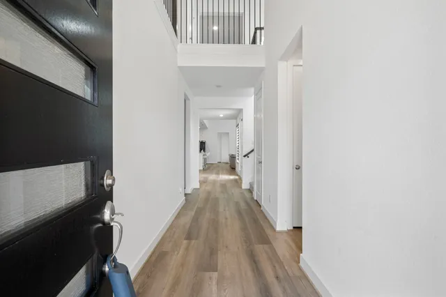 a view of a hallway with wooden floor and staircase