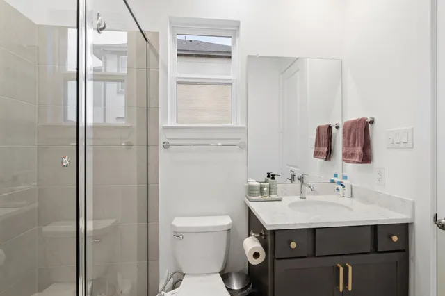 a bathroom with a sink toilet vanity and shower