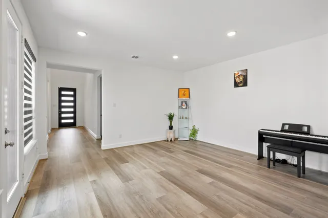 a view of an empty room with wooden floor