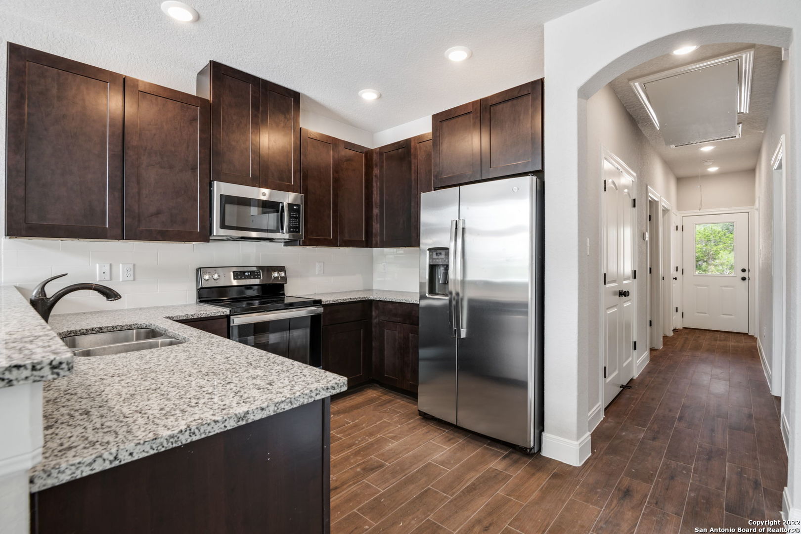 a kitchen with granite countertop stainless steel appliances cabinets a sink and a counter top space