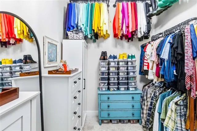 a view of walk in closet with clothes