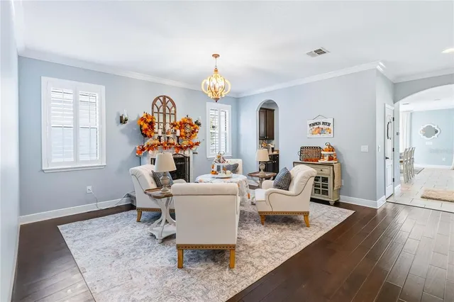 a living room with furniture a chandelier and a window