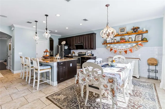 a kitchen with a dining table chairs sink and cabinets