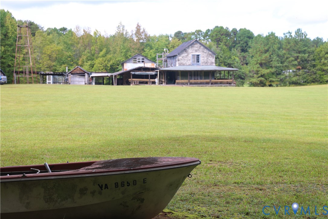 7246 MacDonald Road Scottsburg, VA 24589 - Photo 3 of 46 a view of a swimming pool with lawn chairs and large trees