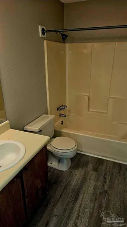 a bathroom with a granite countertop sink toilet a mirror and shower