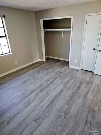 an empty room with wooden floor and closet