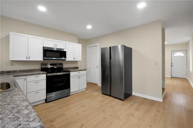 a kitchen with stainless steel appliances granite countertop a refrigerator stove and microwave