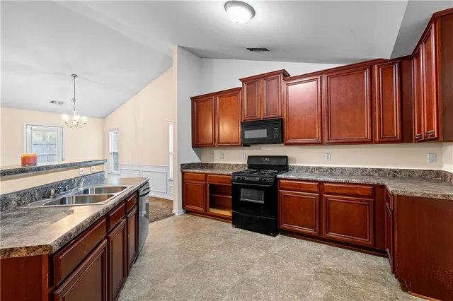 a kitchen with stainless steel appliances granite countertop wooden cabinets a stove top oven a sink and dishwasher