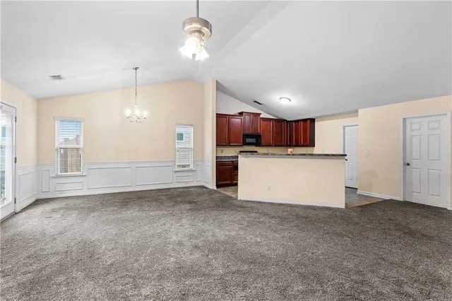 a view of a kitchen with a sink wooden cabinets and window