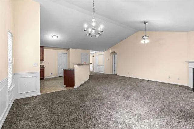 a view of an empty room with a fireplace and a window