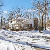 a view of a house with a yard covered in snow