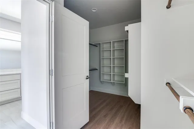 a view of walk in closet with wooden floor