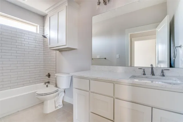 a bathroom with a granite countertop toilet a sink and a bathtub