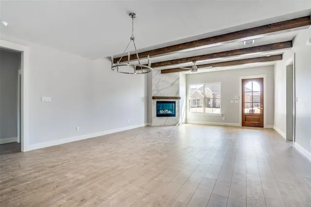 a view of a livingroom with wooden floor a fireplace and window