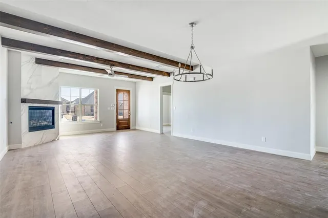 a view of a room with wooden floor a ceiling fan and windows