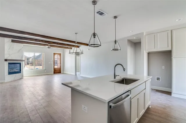 a kitchen with a sink a faucet a fireplace and wooden floor