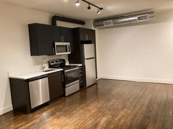 a kitchen with granite countertop a refrigerator and a stove top oven