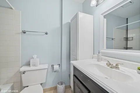 a bathroom with a granite countertop sink a toilet and a mirror