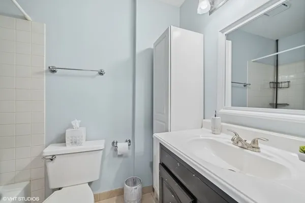 a bathroom with a granite countertop sink a toilet and a mirror