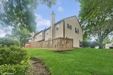 a view of a house with a yard and deck