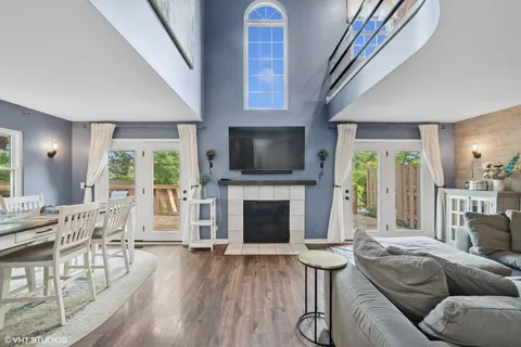 a living room with furniture a fireplace and a floor to ceiling window