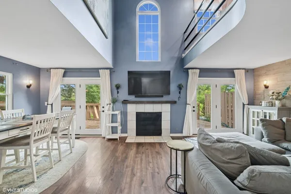 a living room with furniture a fireplace and a floor to ceiling window