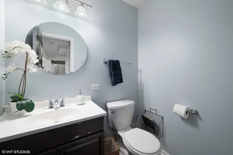 a bathroom with a toilet a sink and mirror