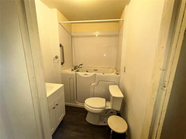 a bathroom with a granite countertop toilet and a sink