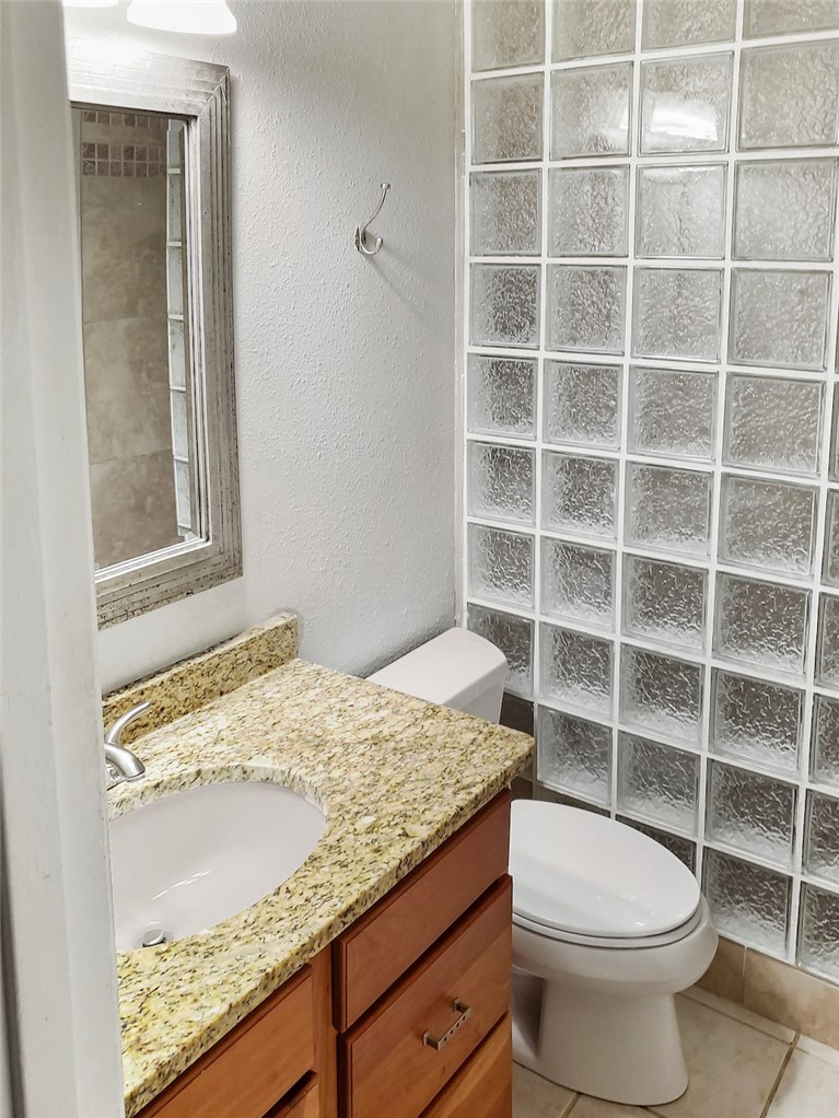 2414 Longview Street, Unit 206 Austin, TX 78705 - Photo 14 of 17 a bathroom with a granite countertop sink a toilet and a window