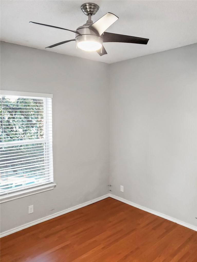 2414 Longview Street, Unit 206 Austin, TX 78705 - Photo 8 of 17 an empty room with wooden floor fan and windows
