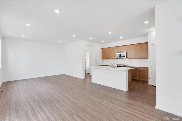 a view of kitchen with granite countertop white cabinets and stainless steel appliances