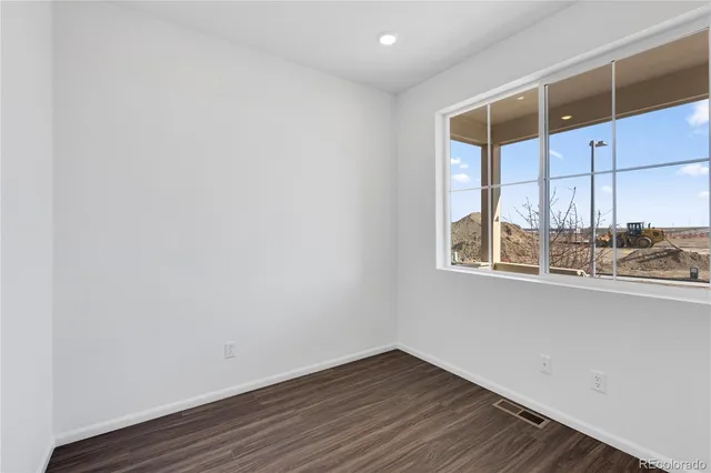 a view of a kitchen with wooden floor and a window