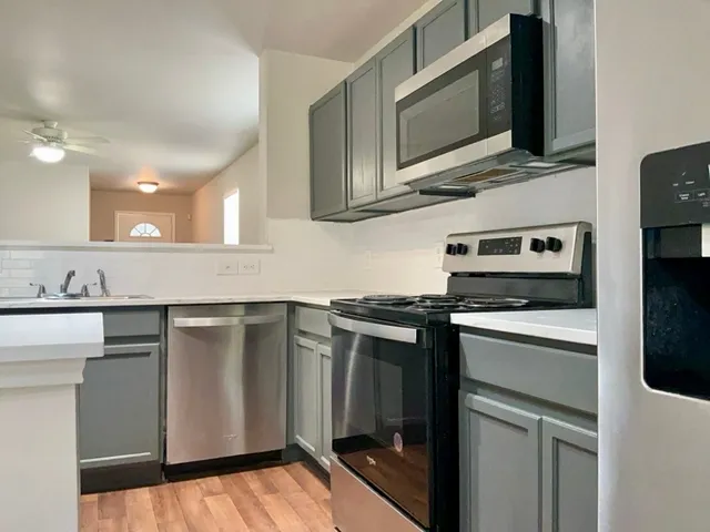 a kitchen with stainless steel appliances a stove microwave and sink