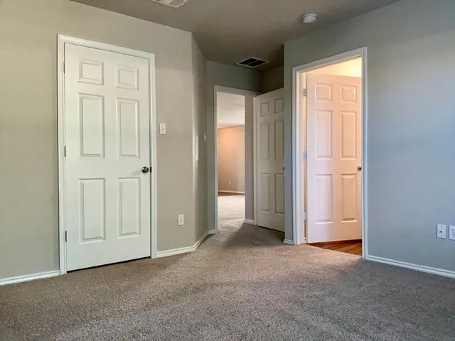 an empty room with windows and closet