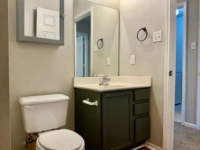 a bathroom with a toilet sink and mirror