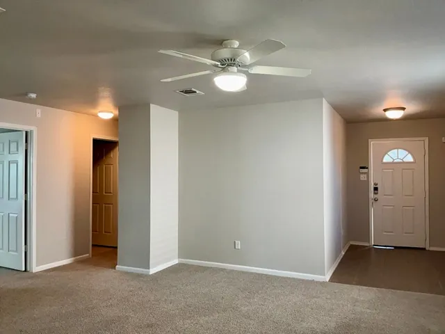 an empty room with closet and a chandelier fan