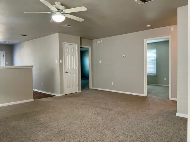 an empty room with closet and a chandelier fan