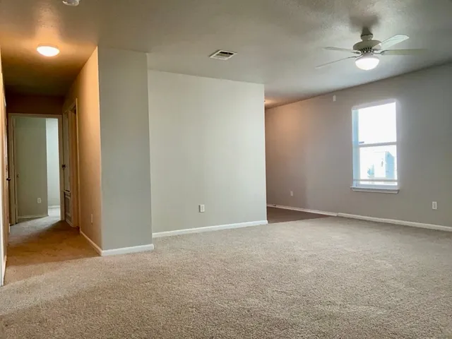 an empty room with windows and fan