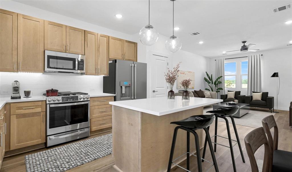 605 Ridgewood Drive Van Alstyne, TX 75495 - Photo 6 of 7 a kitchen with stainless steel appliances kitchen island granite countertop a stove a sink a refrigerator and a refrigerator