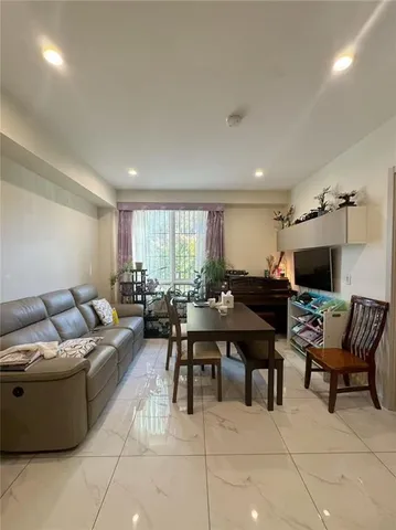 a living room with furniture a flat screen tv and a window