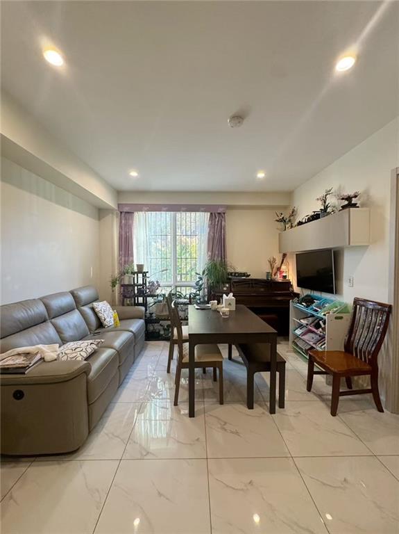 8794 17th Avenue, Unit 101 Brooklyn, NY 11214 - Photo 3 of 8 a living room with furniture a flat screen tv and a window