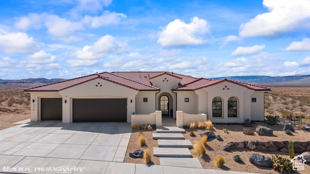 3218 Rimrunner Drive St. George, UT 84790 - Photo 1 of 1 Mediterranean / spanish-style house featuring stucco siding, a tile roof, a mountain view, concrete driveway, and an attached garage