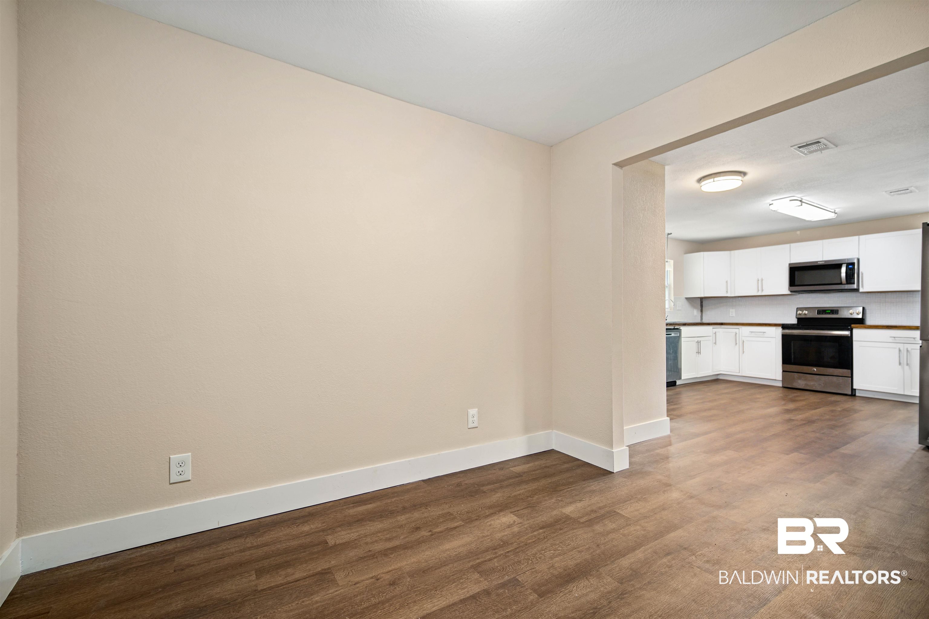 2119 Autrey Avenue Eight Mile, AL 36613 - Photo 10 of 22 Kitchen featuring white cabinetry, appliances with stainless steel finishes, and wood-type flooring