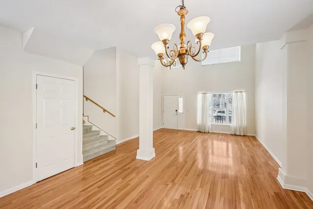 a view of a room with wooden floor and chandelier