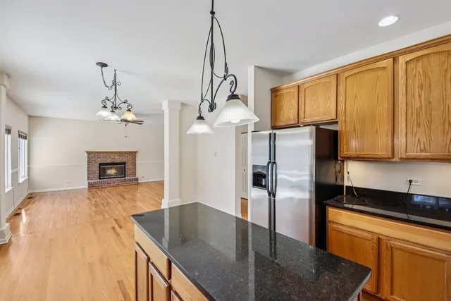 a kitchen with stainless steel appliances granite countertop a refrigerator a stove and a sink with granite countertops