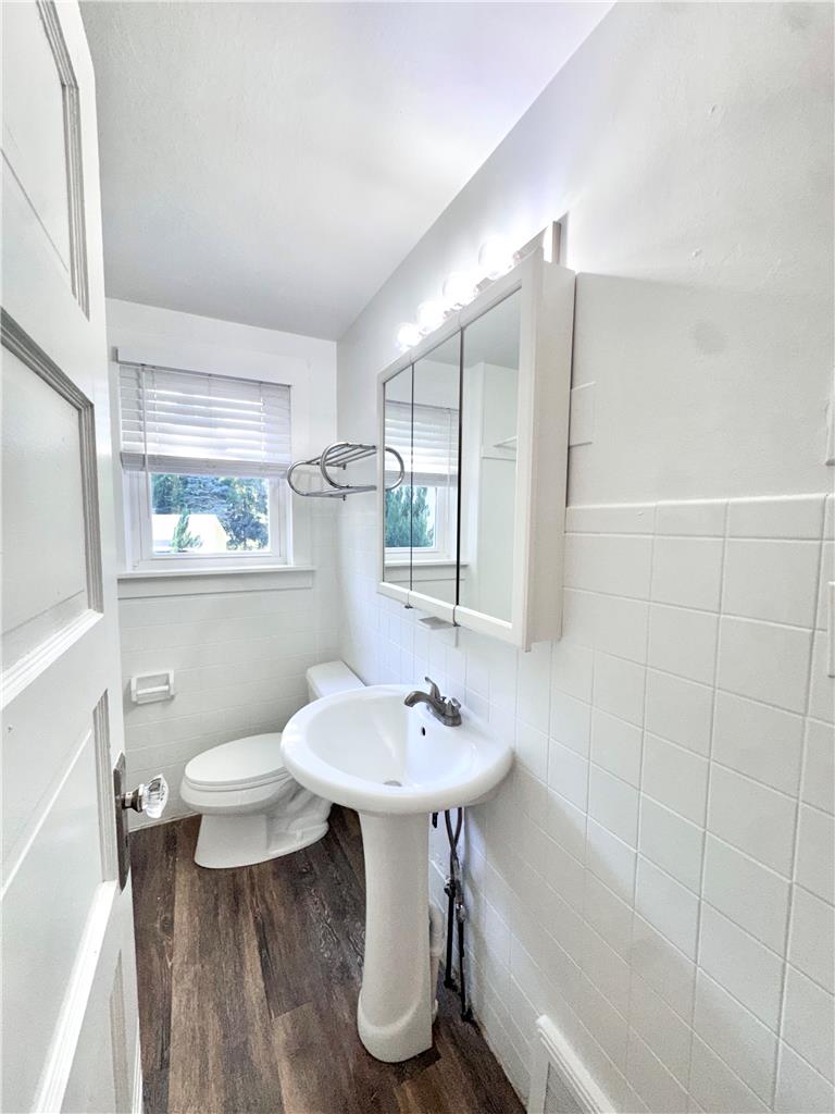 5454 Camp Meeting Road Center Valley, PA 18034 - Photo 17 of 27 A well-lit lavatory features sleek wood-look flooring and a pedestal sink.