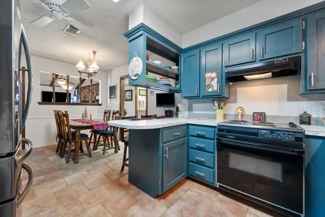 a kitchen with stainless steel appliances granite countertop a stove refrigerator and cabinets